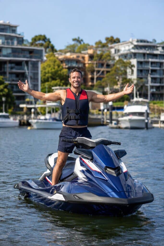 Smiling jet ski rider wearing a life jacket on Sydney Harbour