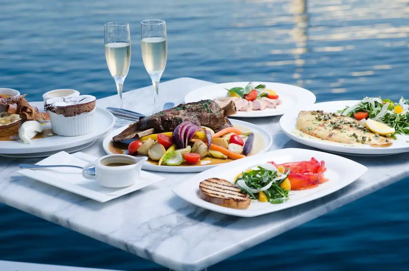 Vela dishes on a table beside the water